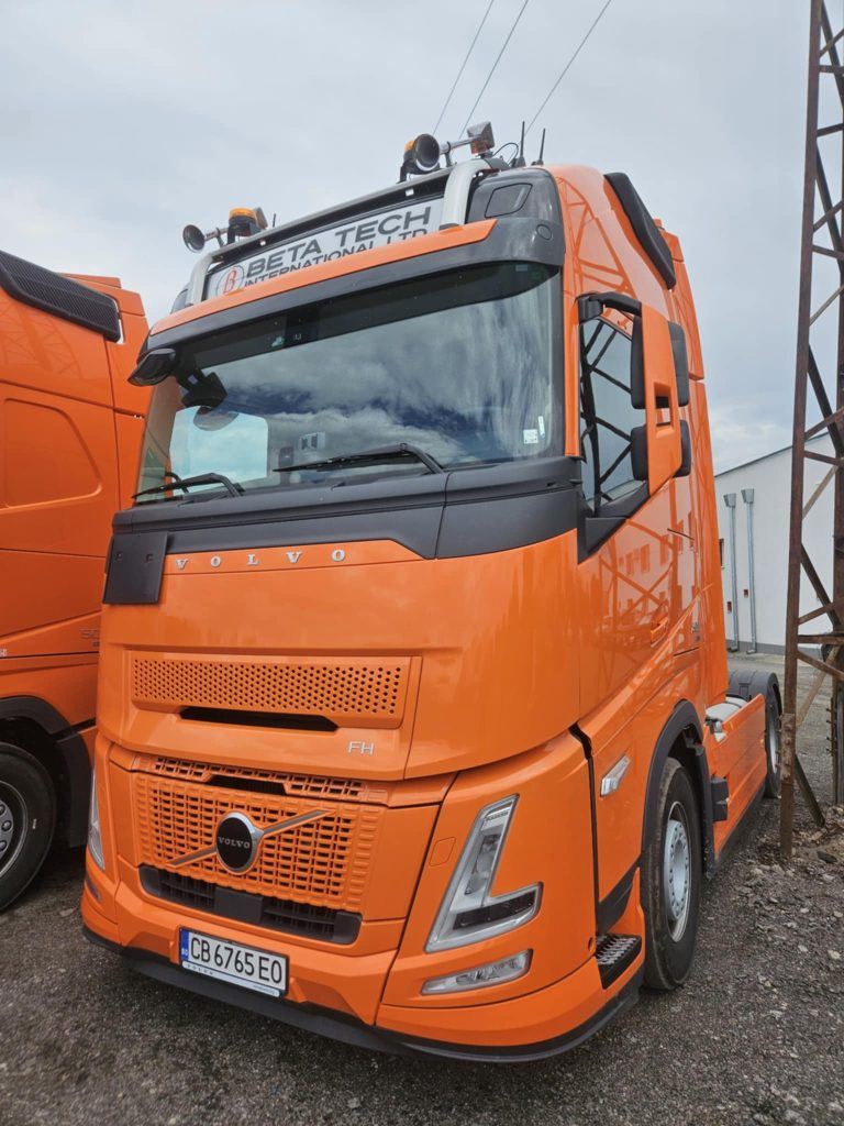 Оранжев камион Volvo с лого Beta Tech International – използван за международен сухопътен транспорт